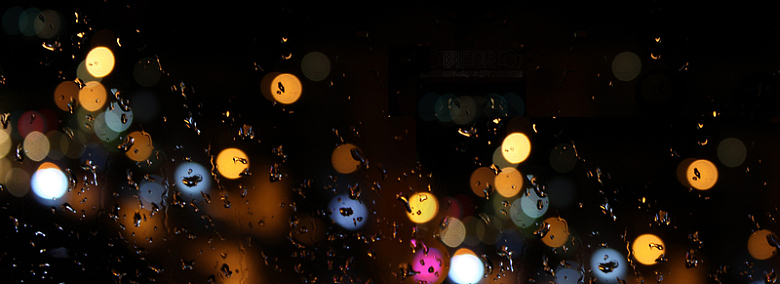 玻璃窗外雨夜中彩色光圈