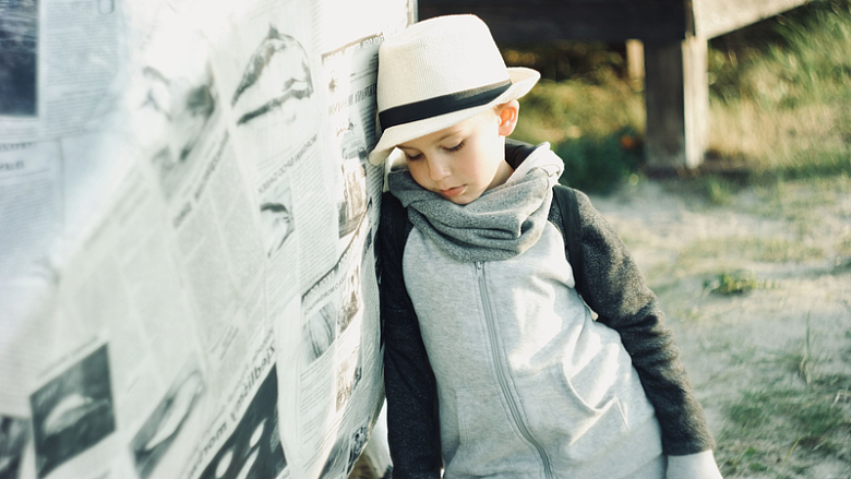 小男孩思考帽子报纸