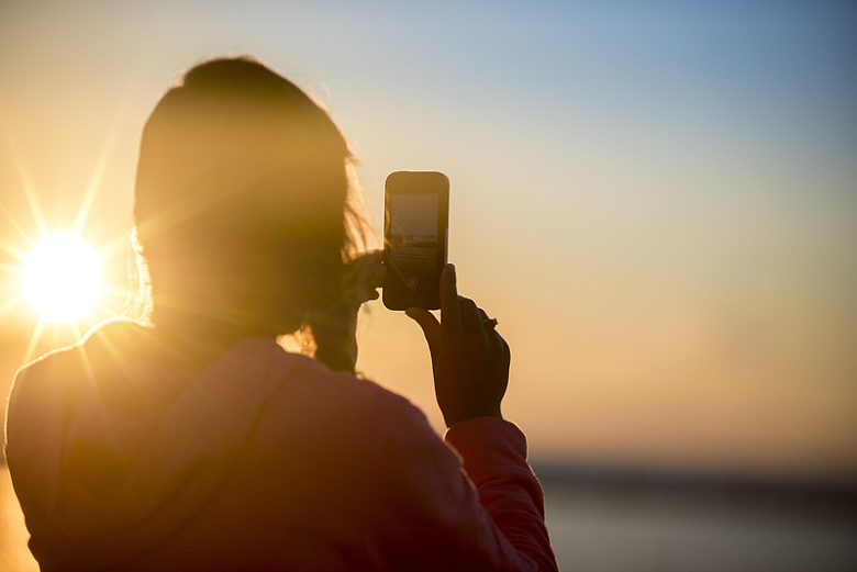 科技智能手机夕阳拍照背影