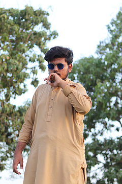 一个穿着棕褐色衣服抽烟的男人