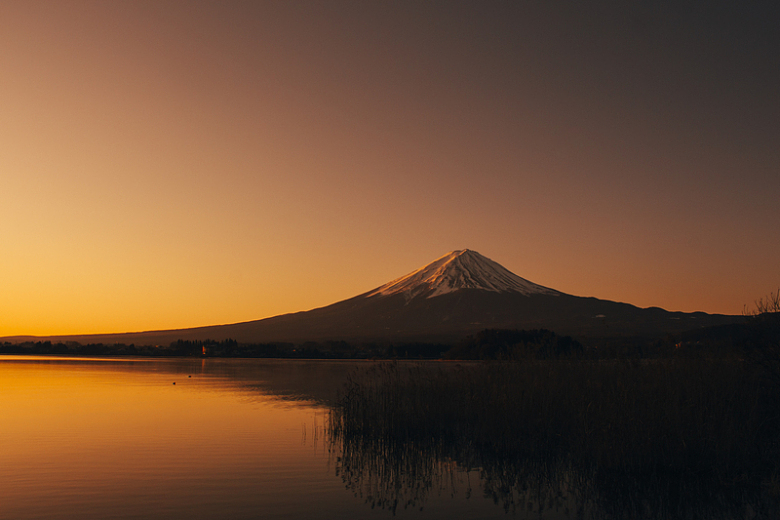 黎明时分湖边山的剪影摄影