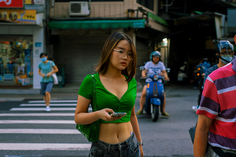 一个穿着绿色上衣的女人站在街上
