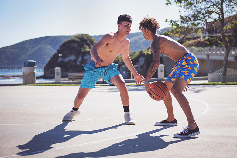 两个赤裸上身的男人在白天打篮球