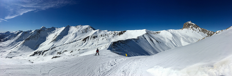 穿着黑色夹克和蓝色裤子的人站在白雪皑皑的山上