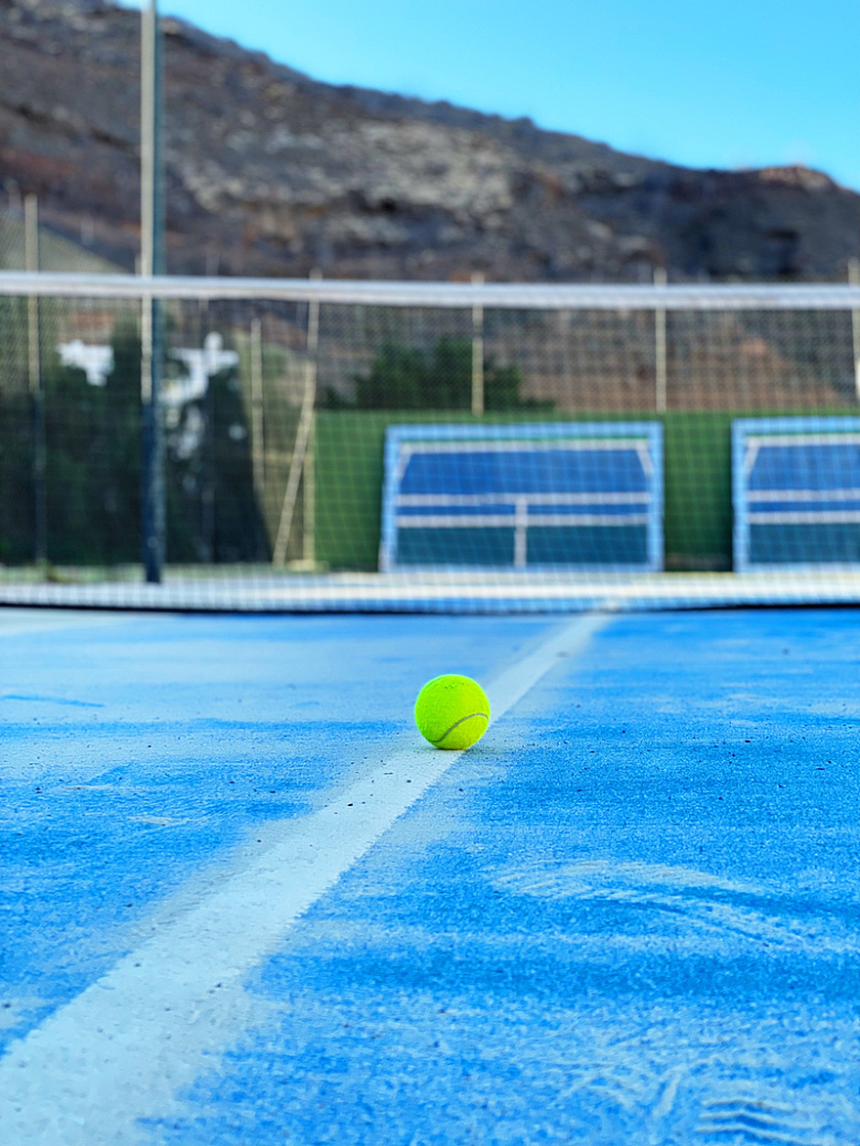 背景是群山的网球场上的网球