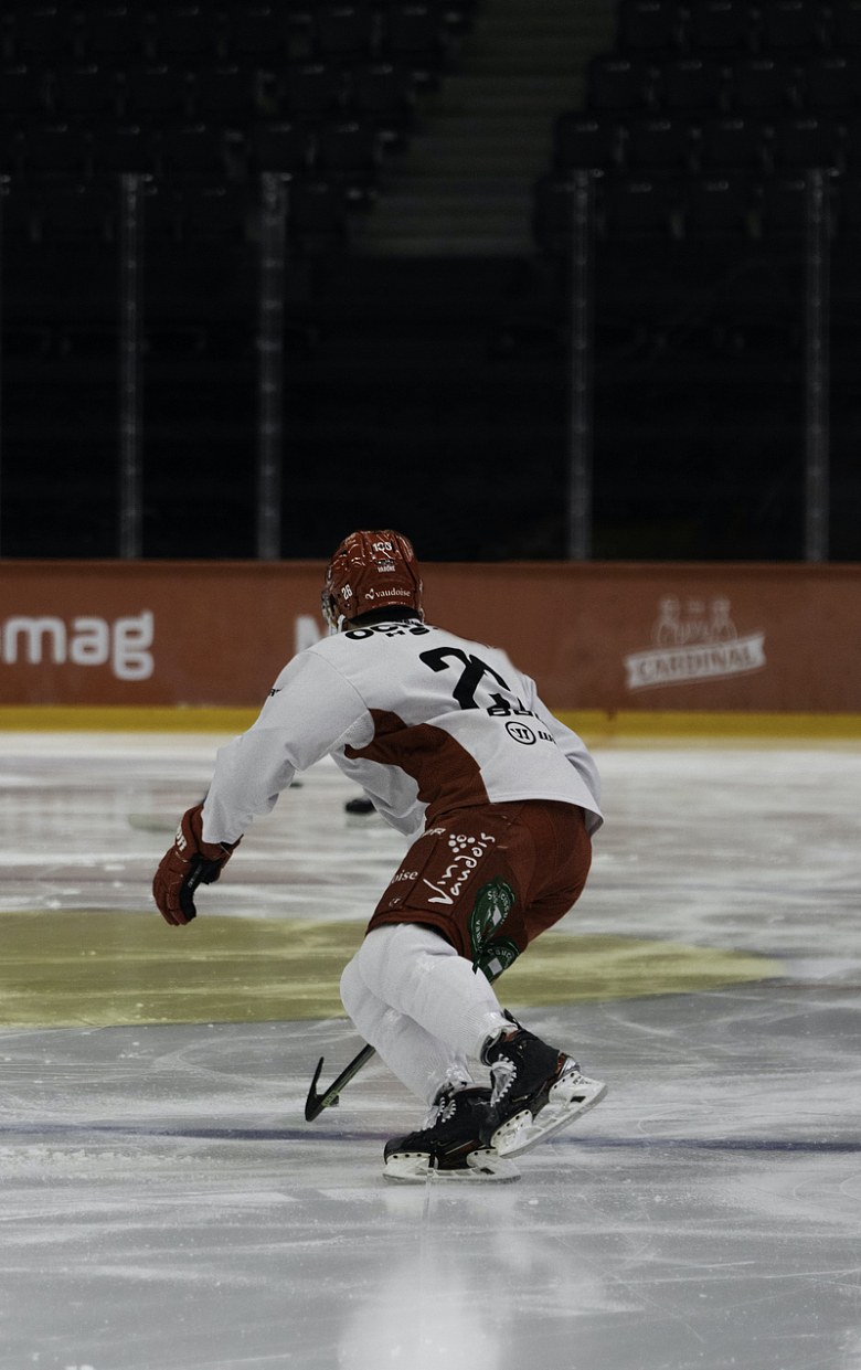 一个穿着白色和棕色制服的男人在溜冰场上滑冰