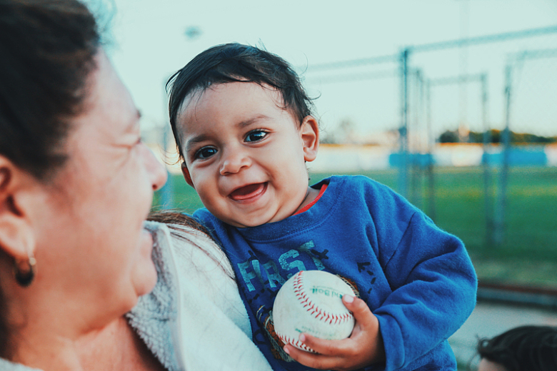 婴儿抱棒球的照片