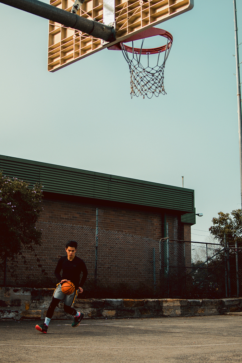 一个年轻人在停车场打篮球