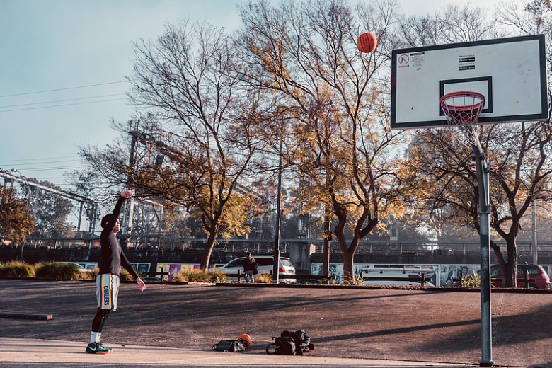 一个男人在停车场打篮球