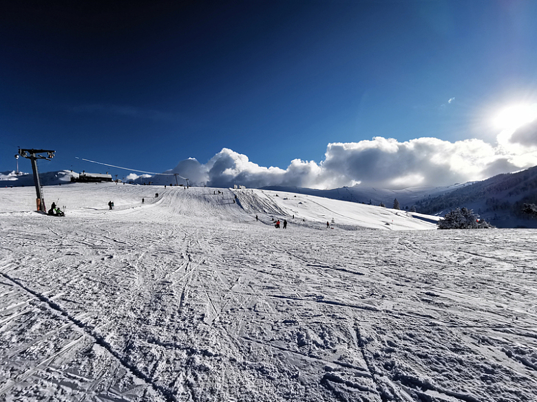 一群人骑着滑雪板从积雪覆盖的斜坡上下来