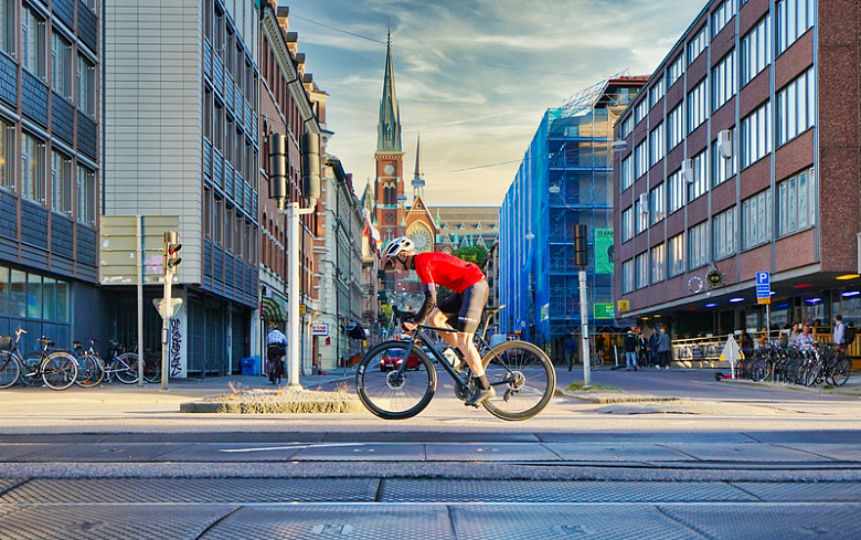 一名身穿红衬衫的男子白天在路上骑自行车