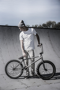 一名男子手持BMX自行车站在自行车道附近