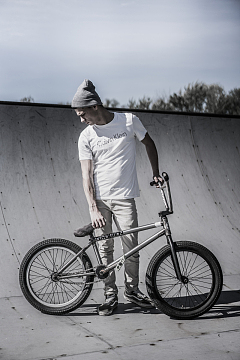 一名男子手持BMX自行车站在自行车道附近