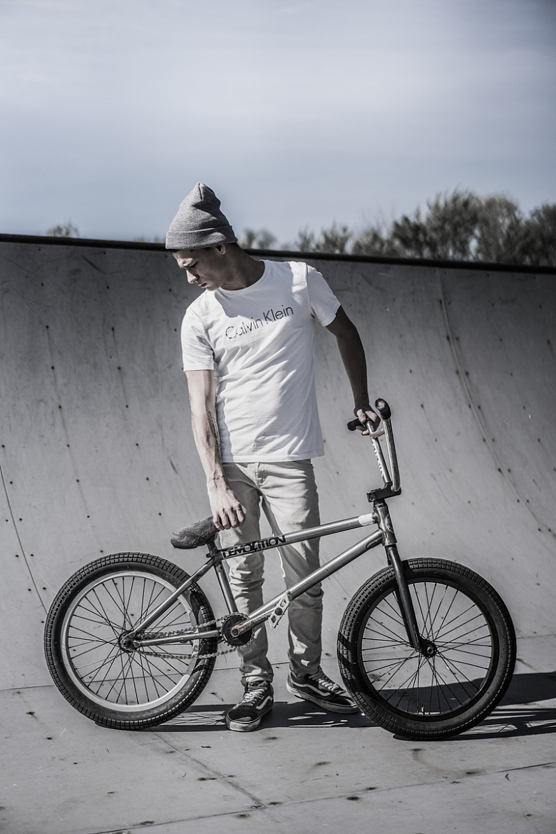 一名男子手持BMX自行车站在自行车道附近