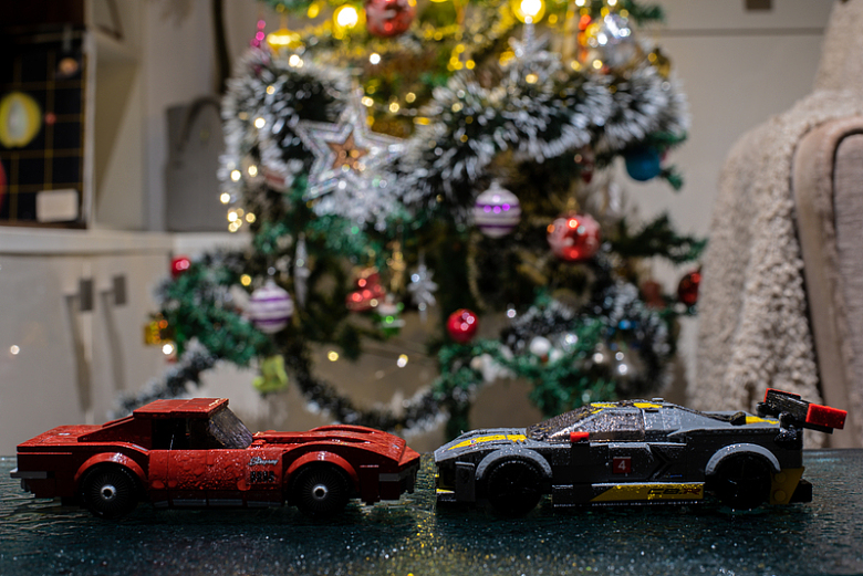 两辆玩具车在圣诞树前的桌子上
