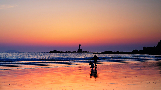 黄昏海边灯塔人物剪影