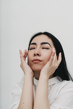 女人闭着眼睛按摩太阳穴