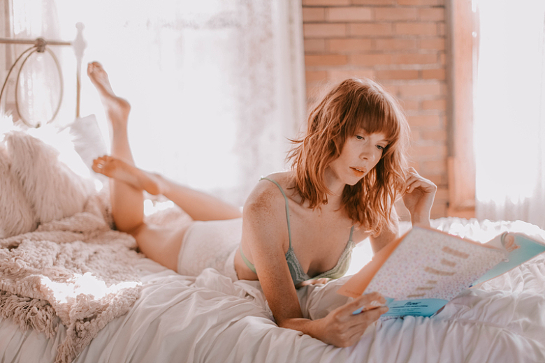美女趴在床上看书