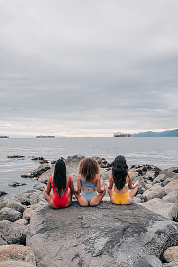 坐在大石头上冥想的女人背影