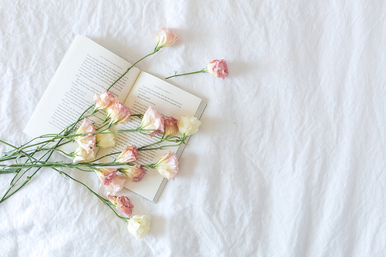 放在床上的一本书与花束