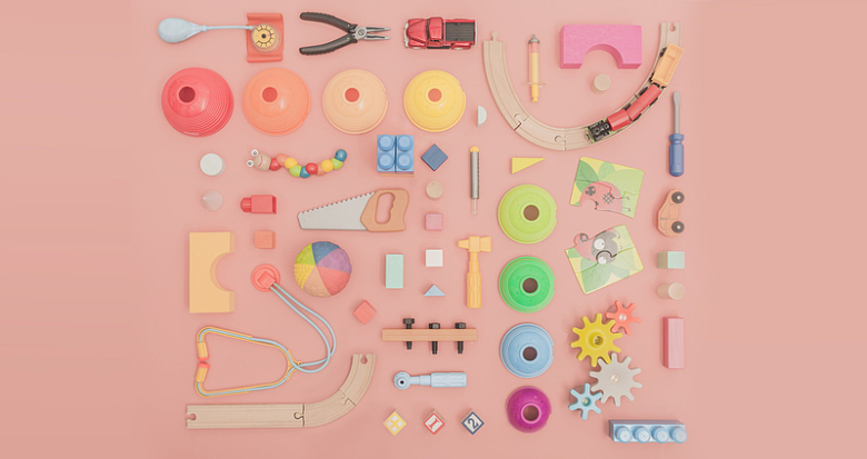 粉红色背景上摆着的各种玩具