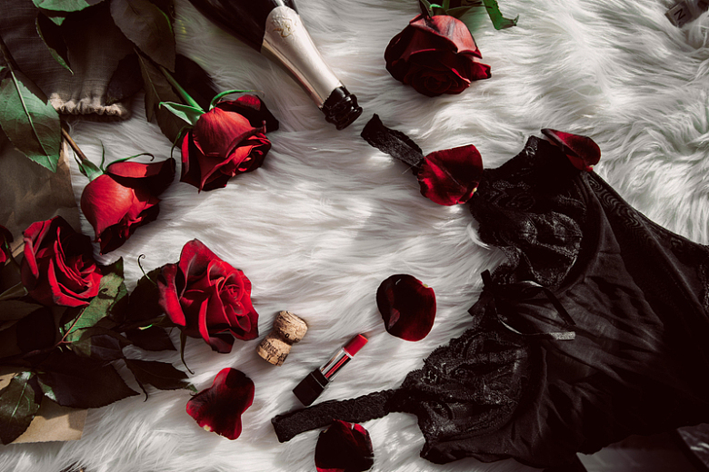 毛皮上放着的香槟玫瑰及睡衣