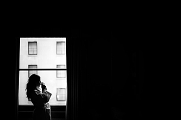窗口的女人拿着早晨的咖啡