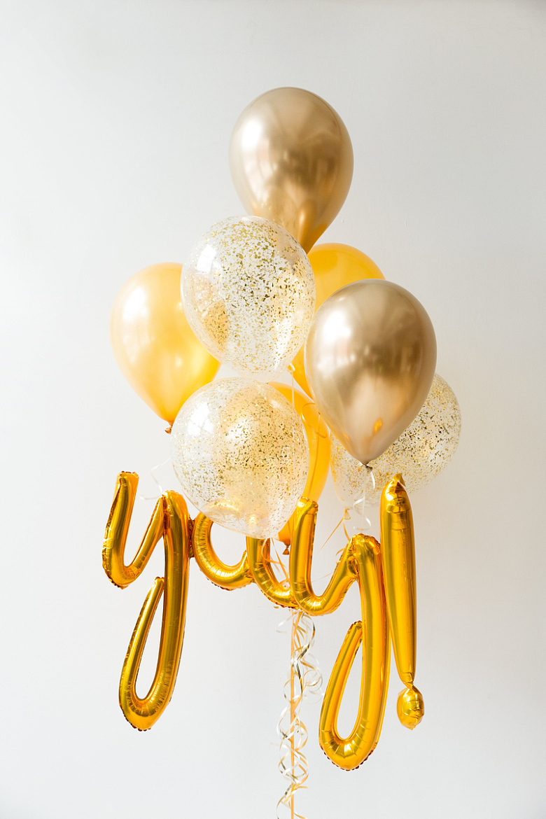 白墙上的金色氦气球