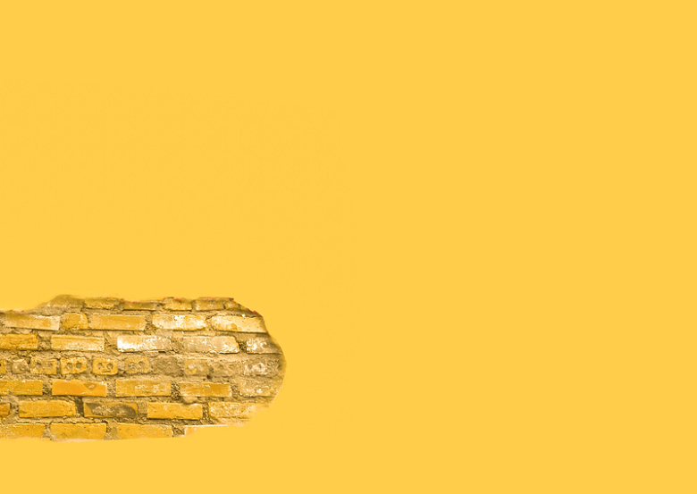 一段裸露砖块的黄色墙壁