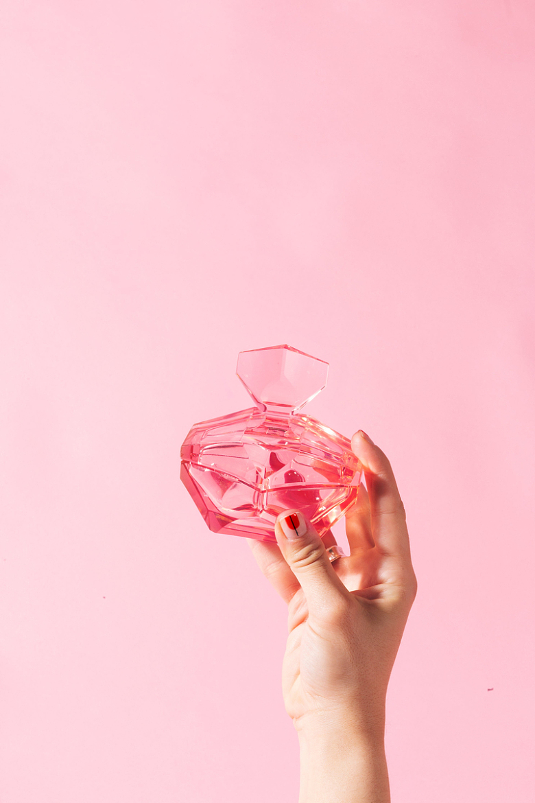 手握粉红色的玻璃瓶
