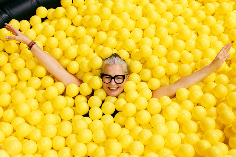 黄色球池里戴眼镜的女人