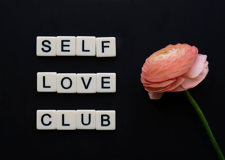 一朵粉红色的花旁边写着自爱俱乐部