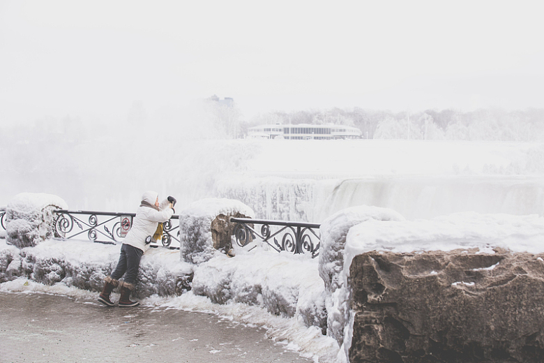 女子拍摄冬季瀑布照片