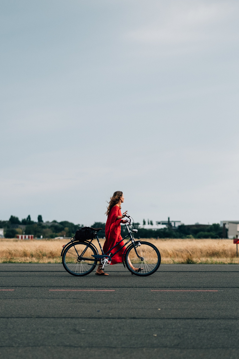 穿红色连衣裙骑自行车的女士