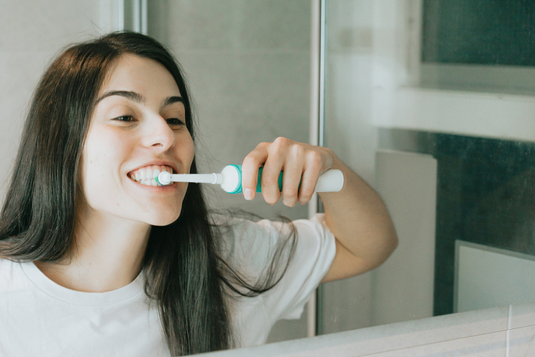 用电动牙刷刷牙的女士