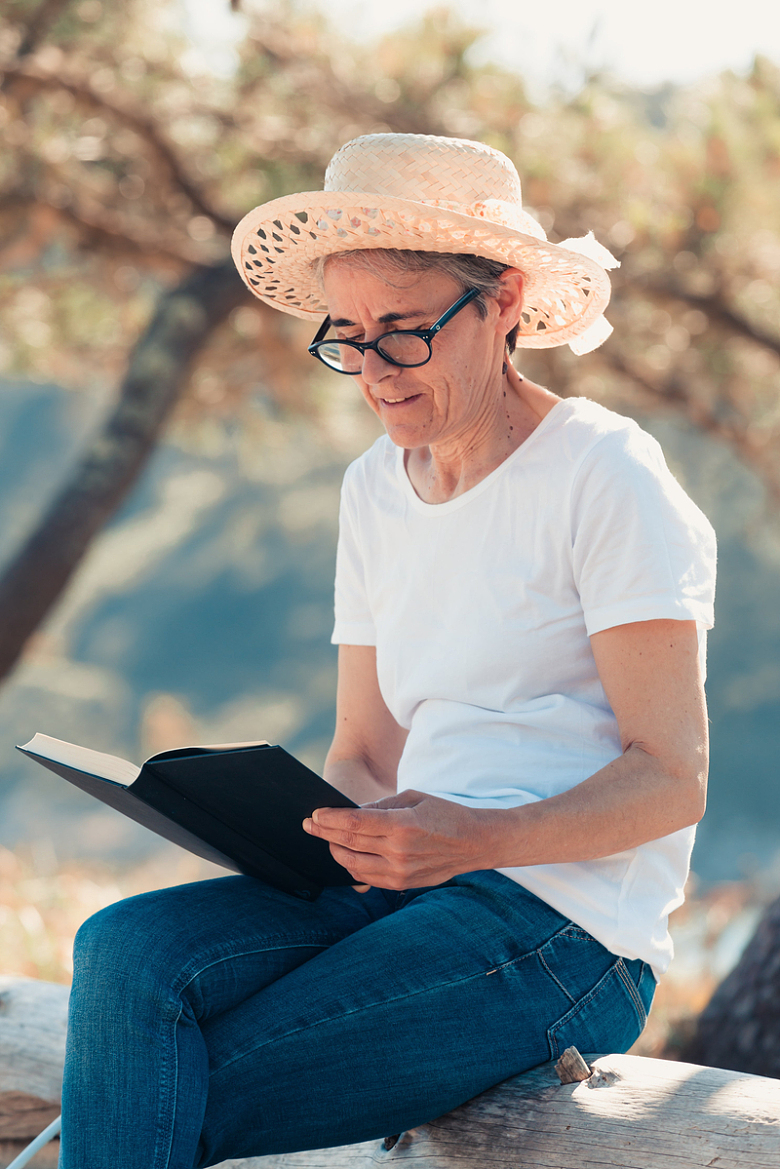 木头上戴草帽的女人在看书
