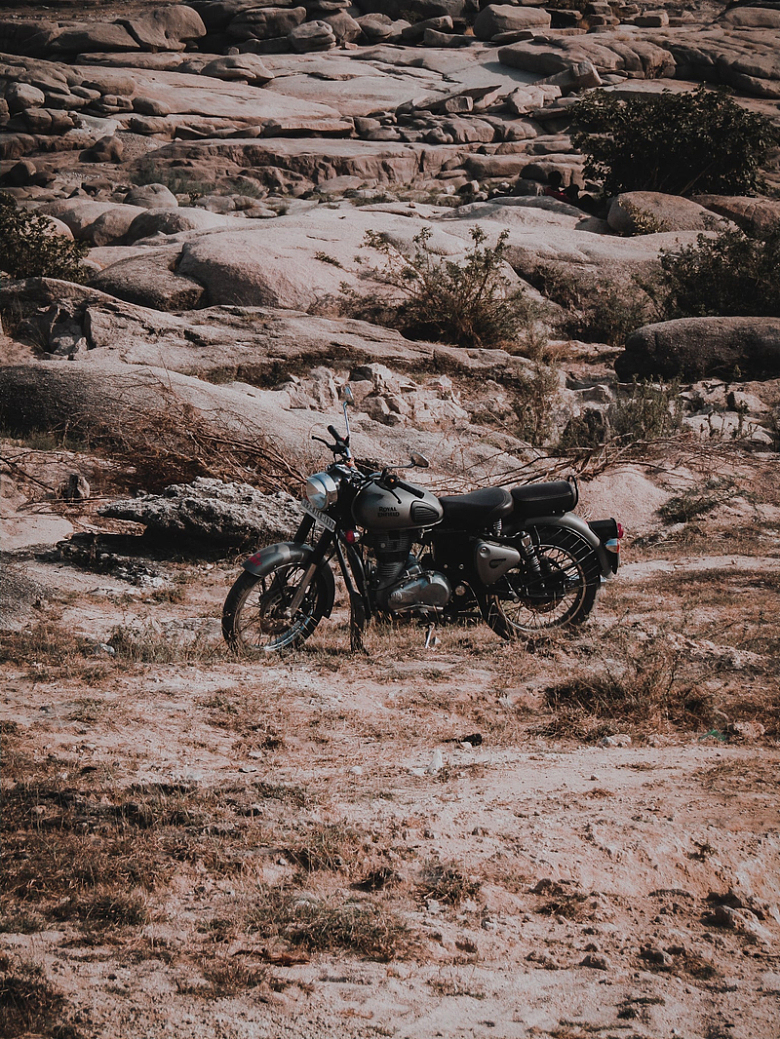 黑色摩托车停在石山后面