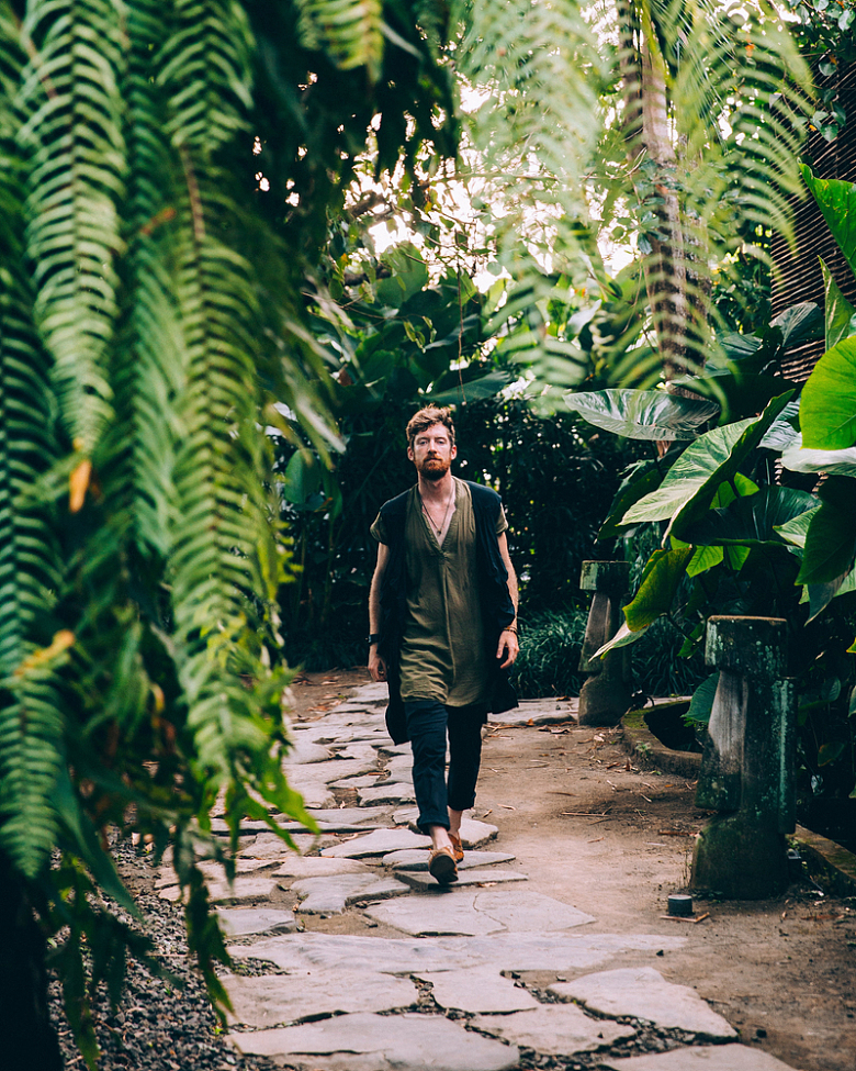 在热带植物雨林里散步的男性