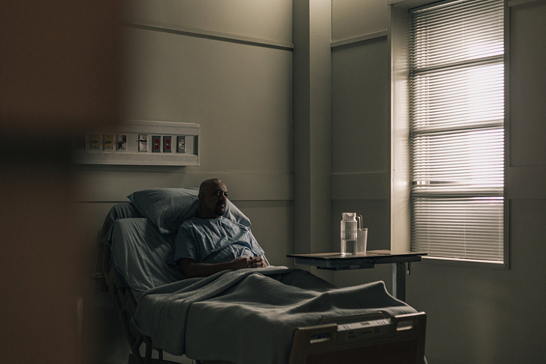 一位住院病人双手交叉坐在床上