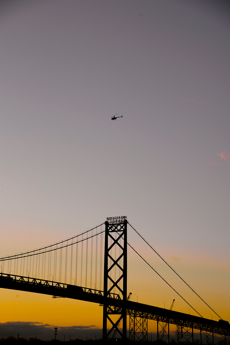 日落时的大桥和直升机