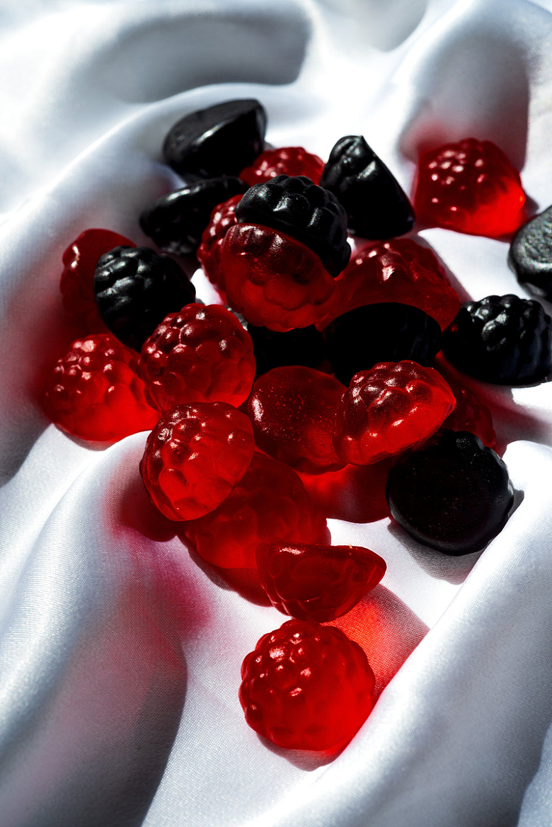 白丝绸上浆果形状的红蓝糖果