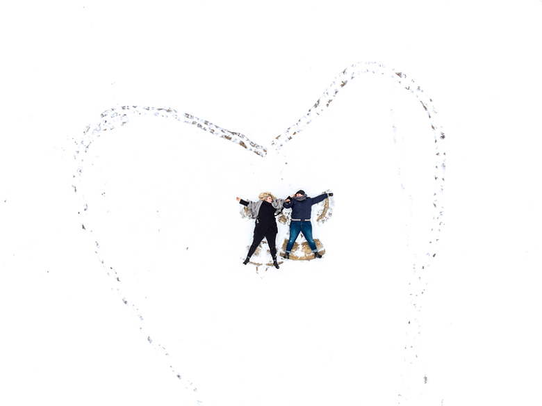 在雪地上画爱心的情侣