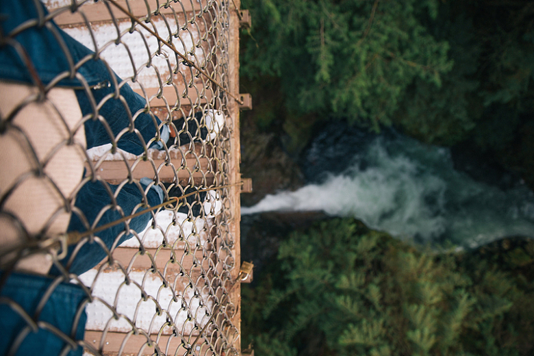 峡谷铁网吊桥下森林的瀑布河流