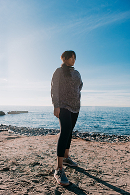 一个女人站在海滩上沉思着