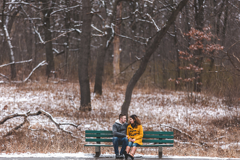 一男一女在雪地公园的长椅上聊天