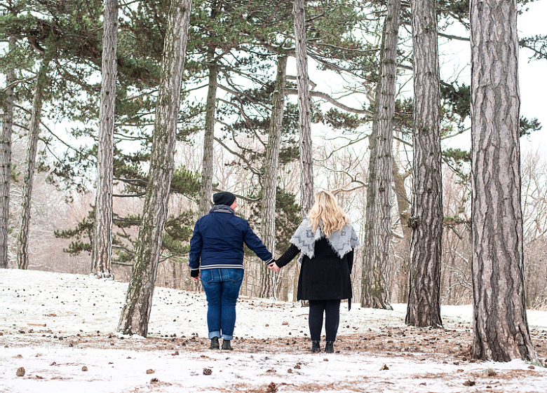 两个人在白雪皑皑的树林里牵着手