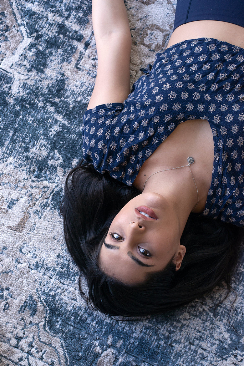 女人躺在蓝色花纹地毯上