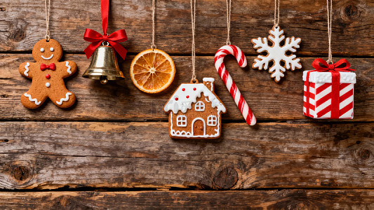 木质背景上悬挂着姜饼人、铃铛和节日装饰品