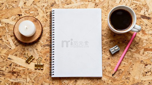 木质桌面摆放笔记本咖啡笔与文具用品