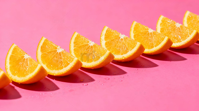 橙片排列在粉色背景上